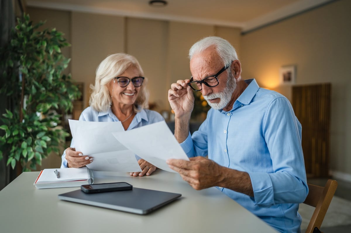 Pareja de adultos mayores revisando su documentación financiera y planeando su pensión del IMSS